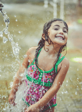 splash pads near gilbert az. Girl playing in sprinkler